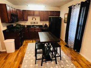 cocina con mesa y nevera negra en Tranquil Townhouse Near Lake, en Guntersville