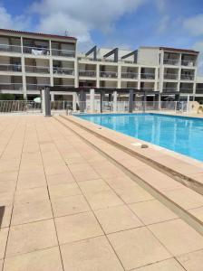 une piscine en face d'un grand bâtiment dans l'établissement Port studio piscine, parking, privé,navette aéroport, au Cap d'Agde