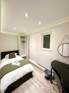 una camera con letto, scrivania e pianoforte di Stylish 3-Bedroom Flat in Prime Location a Londra