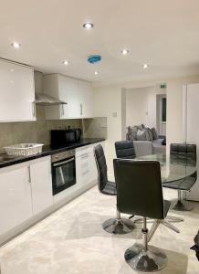 una cucina con tavolo in vetro e sedie nere di Stylish 3-Bedroom Flat in Prime Location a Londra