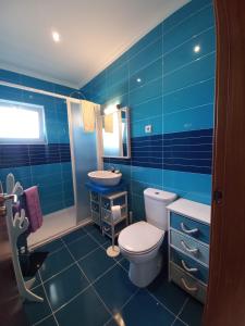 uma casa de banho azul com um WC e um lavatório em Casa do Portão Azul - Salmonete em Atouguia da Baleia