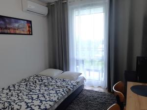 Posteľ alebo postele v izbe v ubytovaní Apartament Zachód