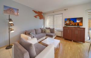 uma sala de estar com um sofá e uma mesa em Lodz4u - Premium Apartment - PIOTRKOWSKA - Garaż - Swiatłowód em Lódź