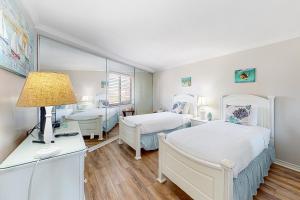 sypialnia z 2 łóżkami i biurkiem z lampką w obiekcie Edgewater Beach Resort 311 w mieście Destin