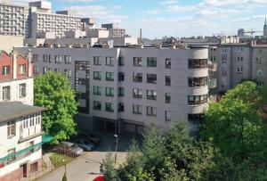 a large white building in a city with buildings at Lodz4rent - Premium Apartment - PIOTRKOWSKA - Garaż - Wakacje 2024 in Łódź