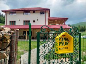 um sinal amarelo numa cerca em frente a uma casa em Poiana Sașilor - Valea Doftanei em Trăisteni