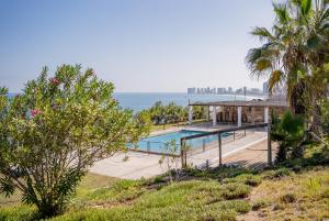 a house with a swimming pool next to the ocean at Cabañas Uma Qala de Primeras Piedras in Iquique