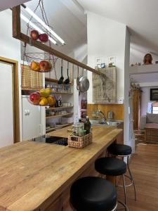 una cocina con una gran barra de madera con taburetes en Popice Hideaway, en Znojmo