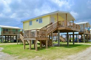 a house with a deck with a bench in front of it at Blue Dolphin Inn and Cottages in Grand Isle
