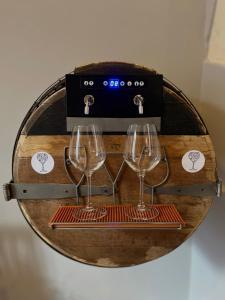 two wine glasses on a wooden table with a box at WineExperience- WINE&JACUZZI SUITE in Lecce