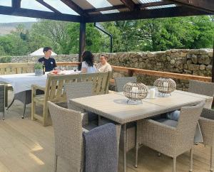 um grupo de pessoas sentadas em mesas num pátio em The Safari Tent @ The Old Forge Glamping em Tullow