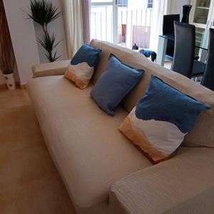 a couch with four pillows on it in a living room at Piso Sierra Calderona a 15 minutos del mar Estivella in Estivella