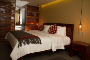 Un dormitorio con una cama grande con almohadas. en Hotel Helverica en San Cristóbal de Las Casas