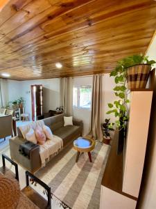 un soggiorno con divano e soffitto in legno di Casa Jataí a Alto Paraíso de Goiás