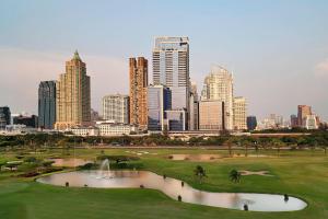 a golf course with a city skyline in the background at The St Regis Bangkok in Bangkok