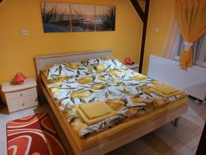 Una cama en un dormitorio con una colcha con comida. en Biagio apartman, en Balatonlelle