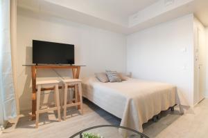 a bedroom with a bed and a flat screen tv at Pramea Apartments Tornitupa in Kuopio