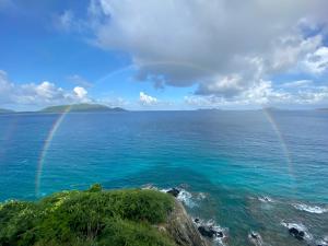 two rainbows over the ocean with a rocky shore at The Aerial, BVI in Tortola Island