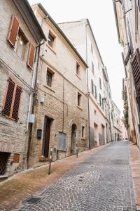 a cobblestone street in an alley between buildings at Osimo Caves Rooms in Osimo