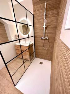 a bathroom with a glass walled shower and a sink at Maison de charme avec Jacuzzi in Mollégès