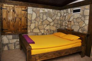 ein Schlafzimmer mit einem Bett in einer Steinmauer in der Unterkunft Skadar Lake House Virpazar in Virpazar
