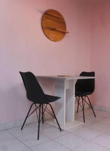 stół z 2 krzesłami i lustrem na ścianie w obiekcie Ranya w Bobo-Dioulasso