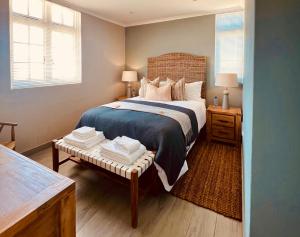 a bedroom with a bed and a table with towels on it at Cape Recife Lighthouse Luxury Villa in Port Elizabeth