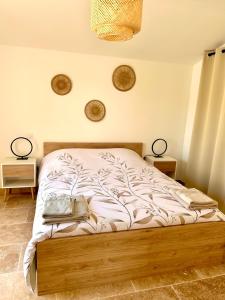 un letto in una camera da letto con due lampade a muro di Maison de charme avec Jacuzzi a Mollégès