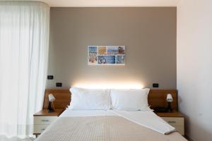 a bedroom with a bed with white sheets and pillows at Hotel D'Atri in Montesilvano