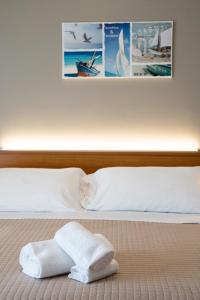 uma cama com duas toalhas em cima em Hotel D'Atri em Montesilvano