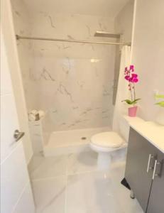 La salle de bains blanche est pourvue d'une douche et de toilettes. dans l'établissement Insta Worthy Oasis, à Homestead