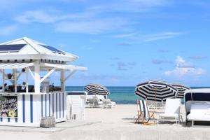 - un groupe de chaises longues et de parasols sur la plage dans l'établissement Insta Worthy Oasis, à Homestead