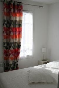 a bedroom with a bed and a window at Villa à deux pas de la cité médiévale dans une résidence très calme in Aigues-Mortes
