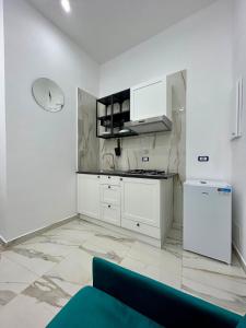 una cucina con armadi bianchi e un divano blu di Sasy Home a Napoli