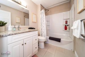 biała łazienka z toaletą i umywalką w obiekcie Cozy 3BD w/AC, Patio, Theatre Room, 15 min to DT w mieście Edmonton