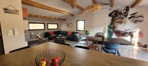 a living room with a large wooden table and chairs at L'ENTRE POTES - Maison de caractère climatisée avec garage in Villedieu