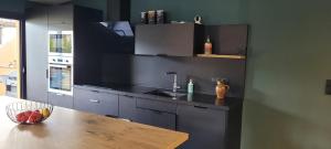 a kitchen with a sink and a wooden table at L'ENTRE POTES - Maison de caractère climatisée avec garage in Villedieu +24 photos
