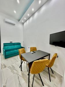una sala da pranzo con tavolo, sedie e divano di Sasy Home a Napoli Altre 14 foto