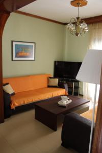 - un salon avec un canapé orange et une table dans l'établissement Comfortable Apartment in the Center of Alexandroupolis, à Alexandroúpolis