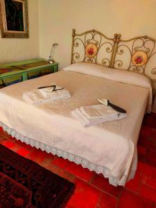 Una cama con dos toallas y un cuchillo. en Residence La Villa en Montescudaio