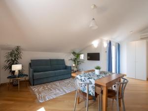 ein Wohnzimmer mit einem blauen Sofa und einem Tisch in der Unterkunft Appartamento Pesco "A Casa Felice" in Pietra Ligure