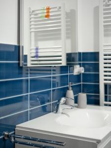 a bathroom with a sink and blue tiled walls at Appartamento Melograno "A Casa Felice" in Pietra Ligure