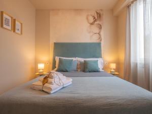 a bedroom with a large bed with two lamps at Appartamento Melograno "A Casa Felice" in Pietra Ligure