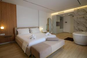 a bedroom with a large bed and a bath tub at Julia Hotel in Sarandë