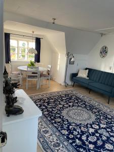 sala de estar con sofá azul y mesa en ØsterLars blue Pearl, en Gudhjem