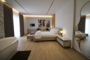 a bedroom with a bed and a bath tub and a bathroom at Julia Hotel in Sarandë