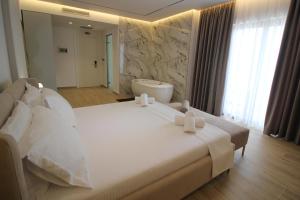a bedroom with a large bed and a bath tub at Julia Hotel in Sarandë