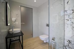 a bathroom with a toilet and a sink and a shower at Julia Hotel in Sarandë