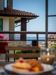 a plate of food on a table with a view of the ocean at Buongiorno! Premium in Sveti Vlas