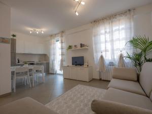 a living room with a couch and a kitchen at Appartamento Lavanda "A Casa Felice" in Pietra Ligure